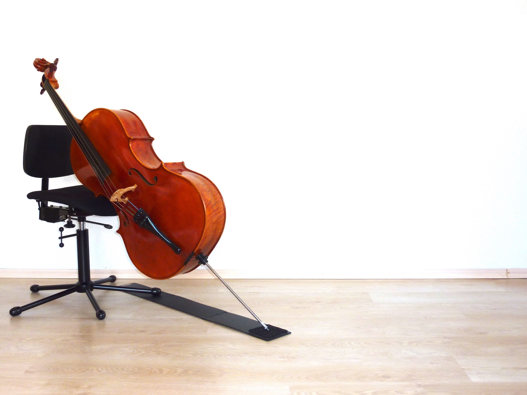 Cello, das auf dem Raabe-Celloteppich auf dem Boden steht